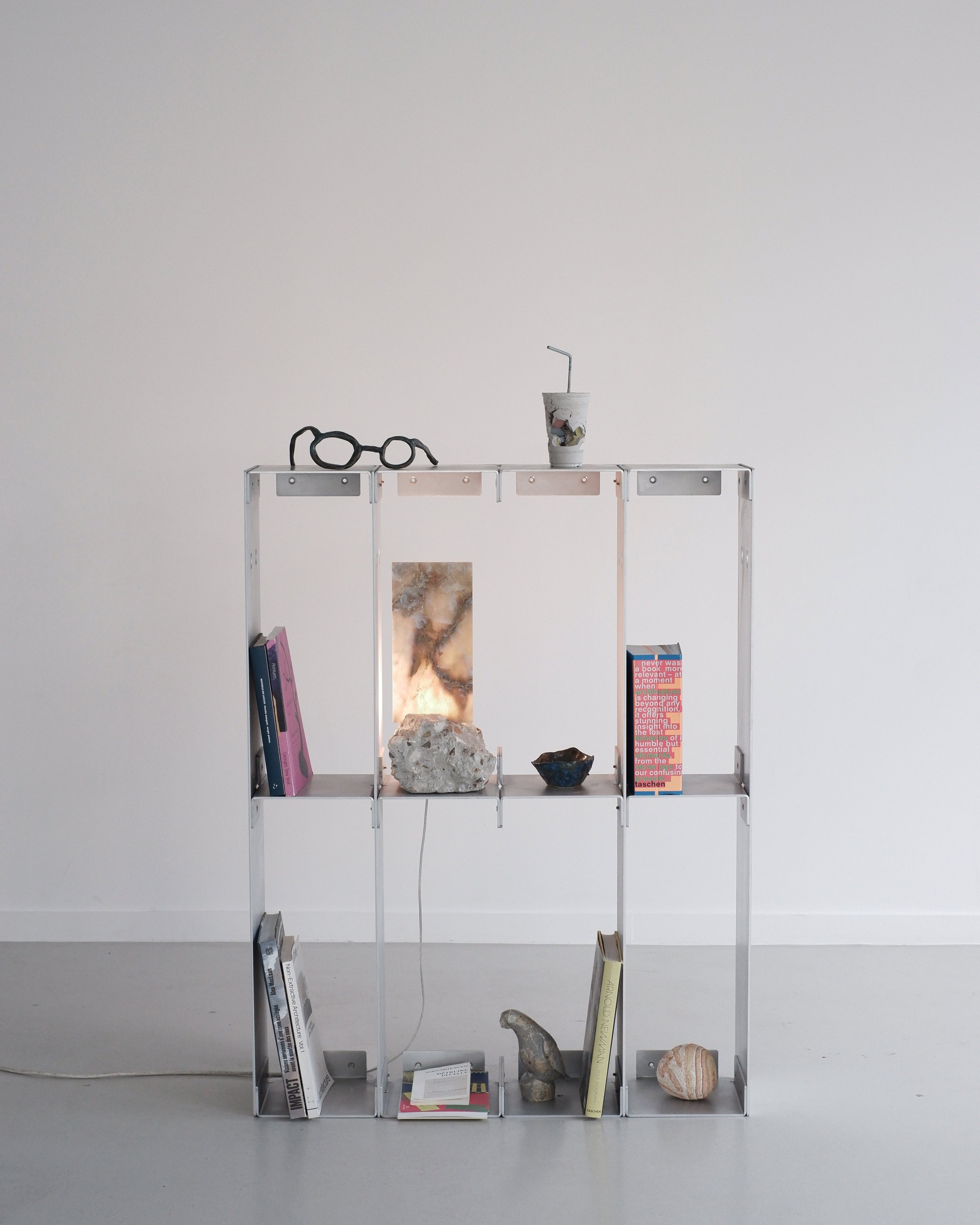 metal shelf with various items against a white wall