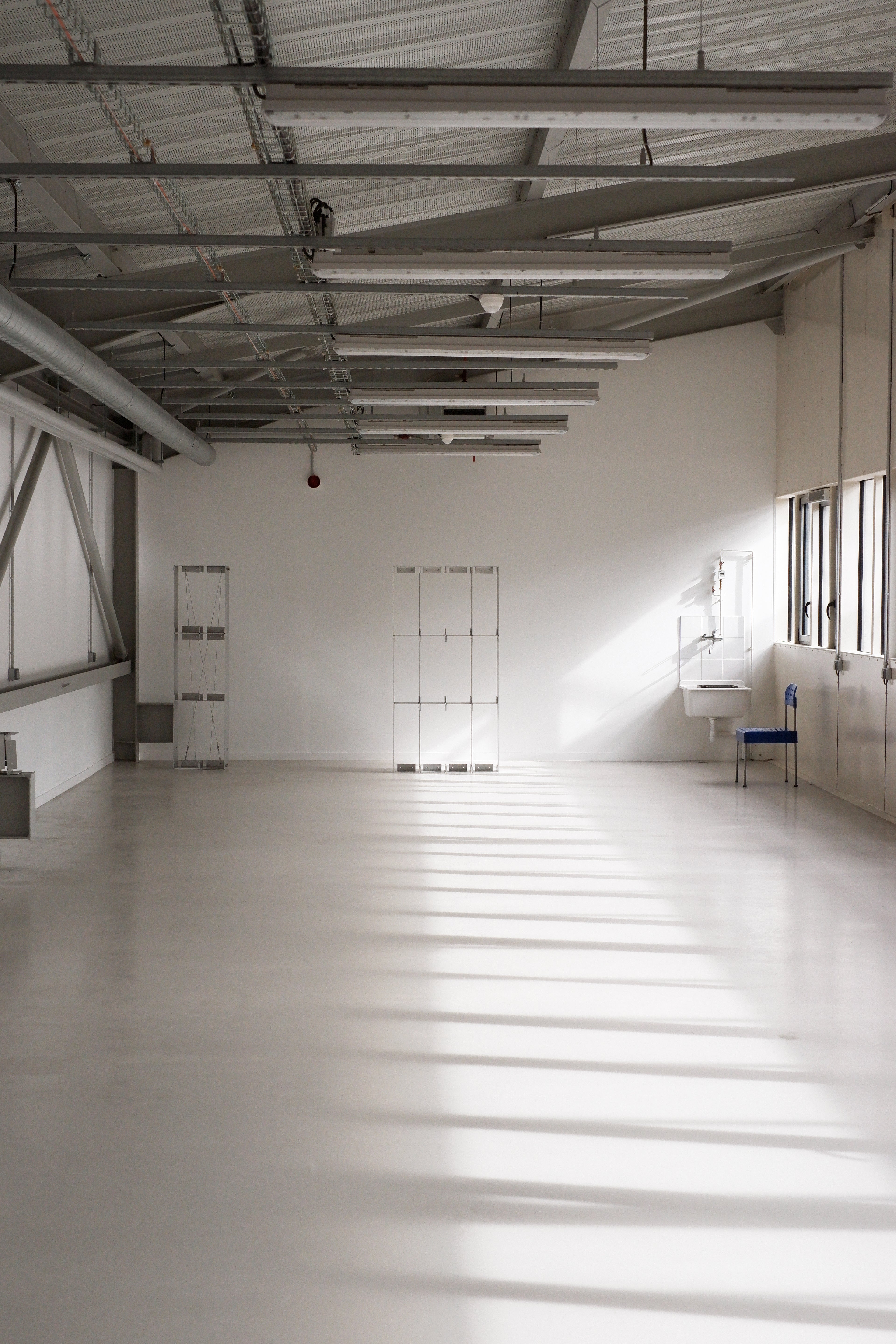 Large industrial or warehouse space with high ceilings and concrete floor.