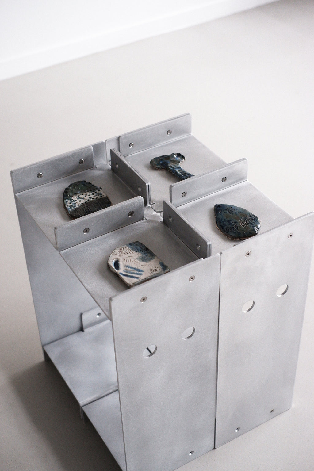 Metallic table with stones on a white background