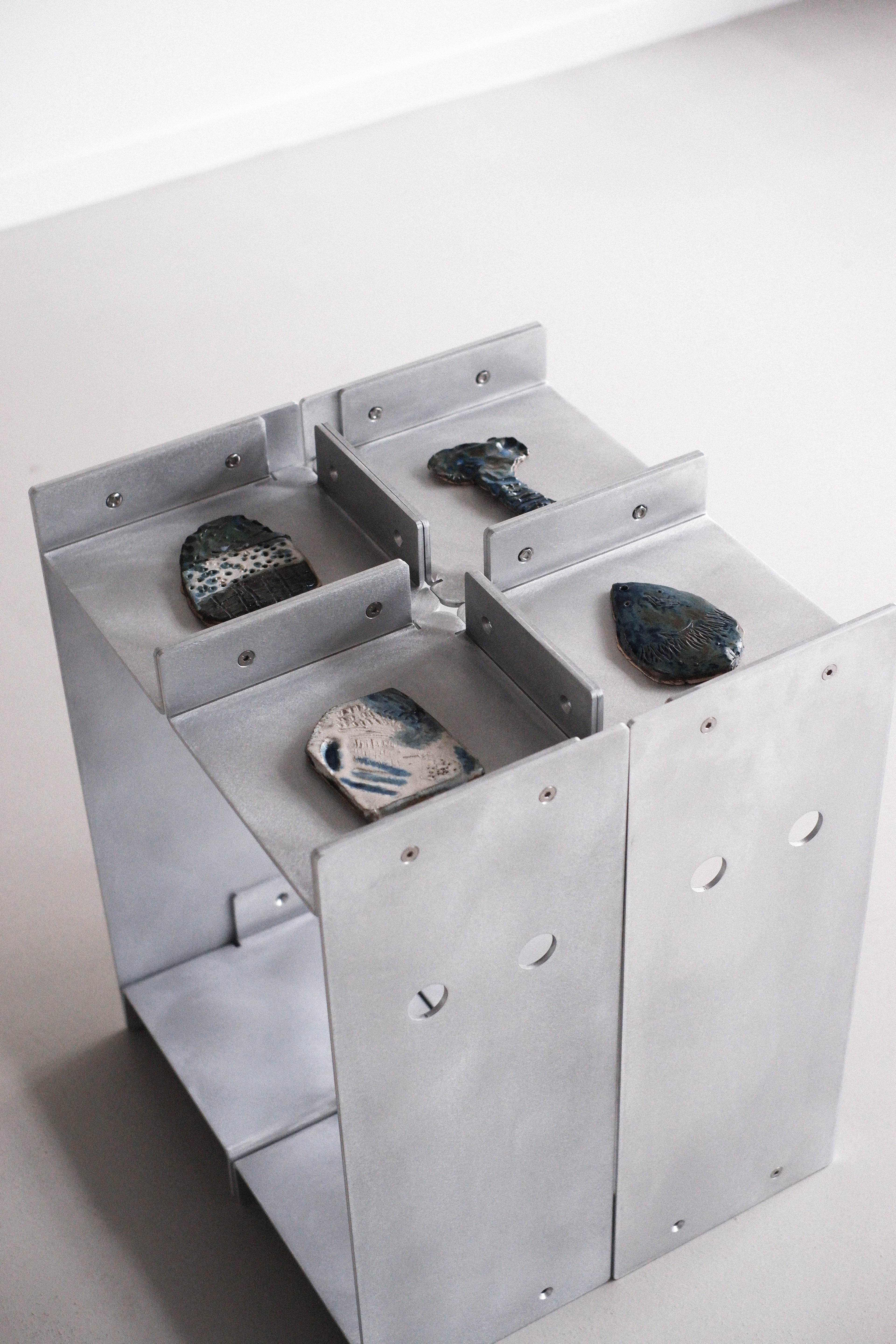 Metallic table with stones on a white background