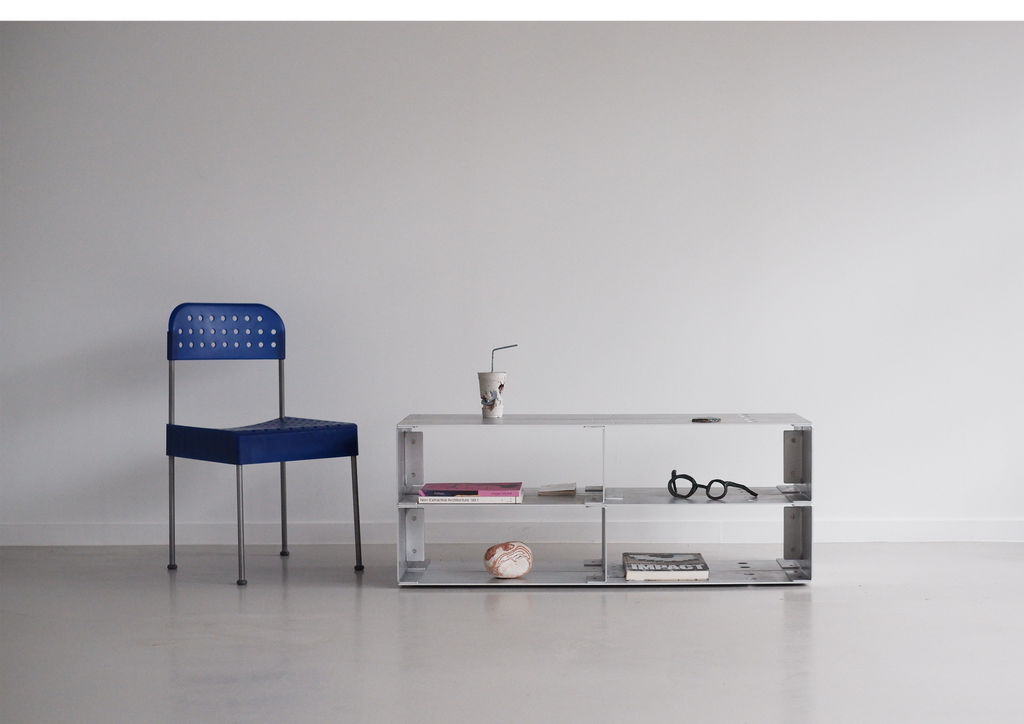 chair and metal coffee table with decorative items on a plain background