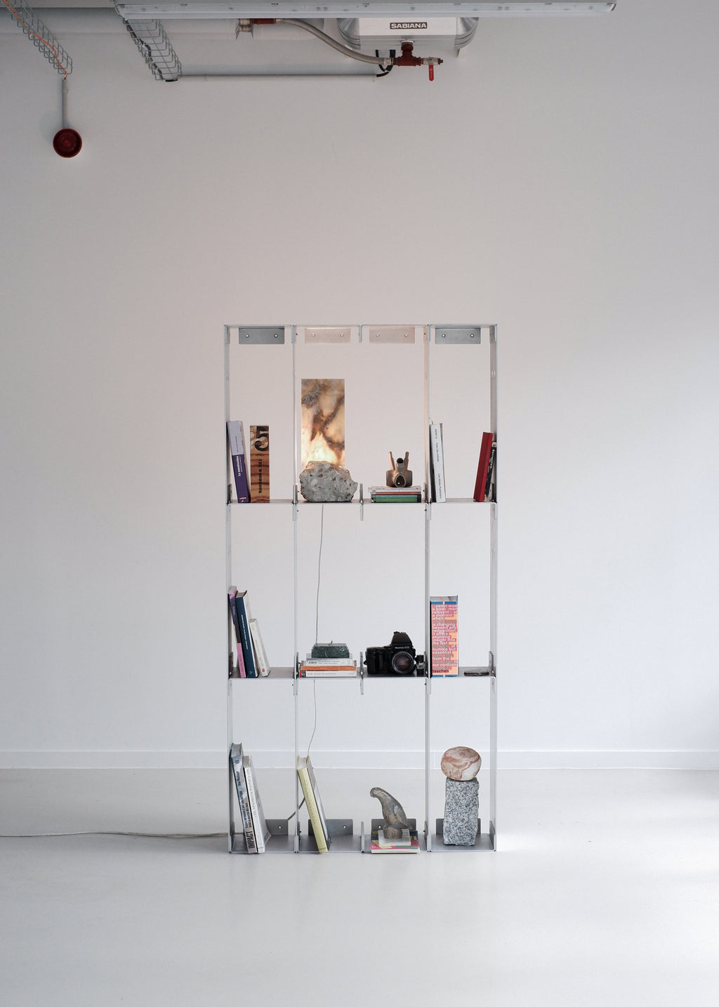 metal shelf with various items against a white wall