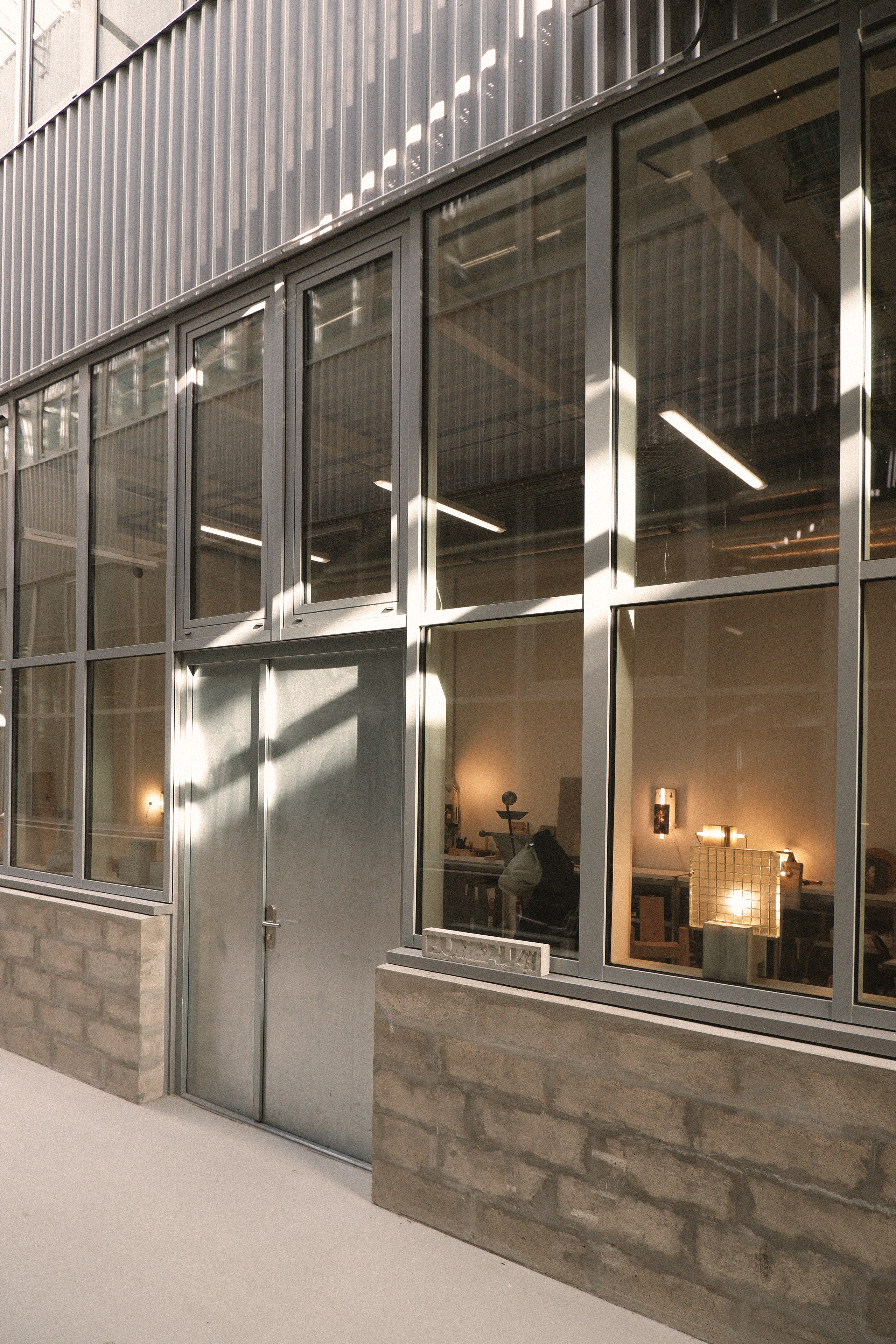 Modern building facade with large glass windows and stone base.