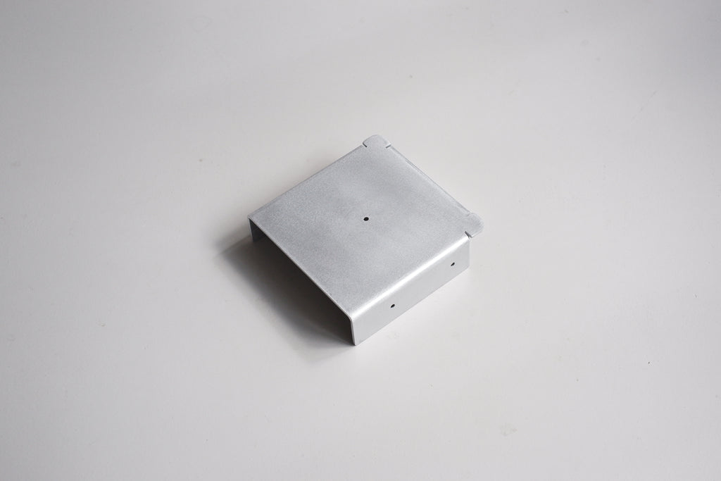 Metallic square object on a light gray background