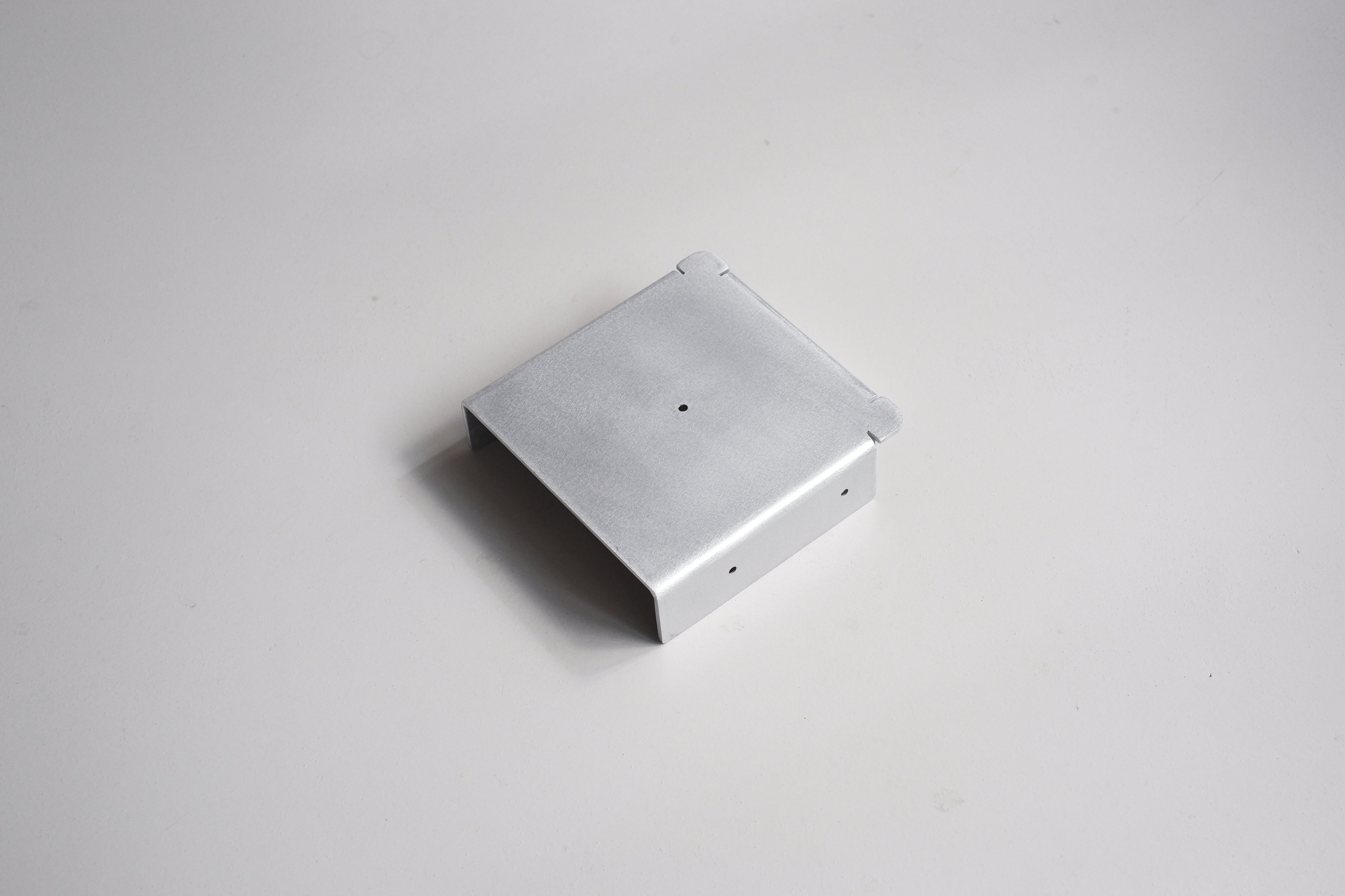 Metallic square object on a light gray background