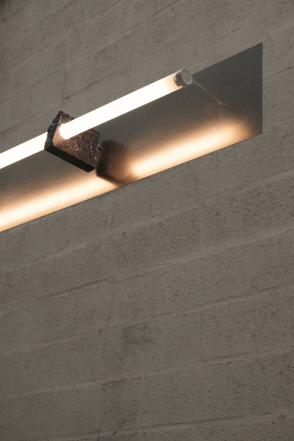 A modern track lighting fixture mounted on a wall, with LED lights.