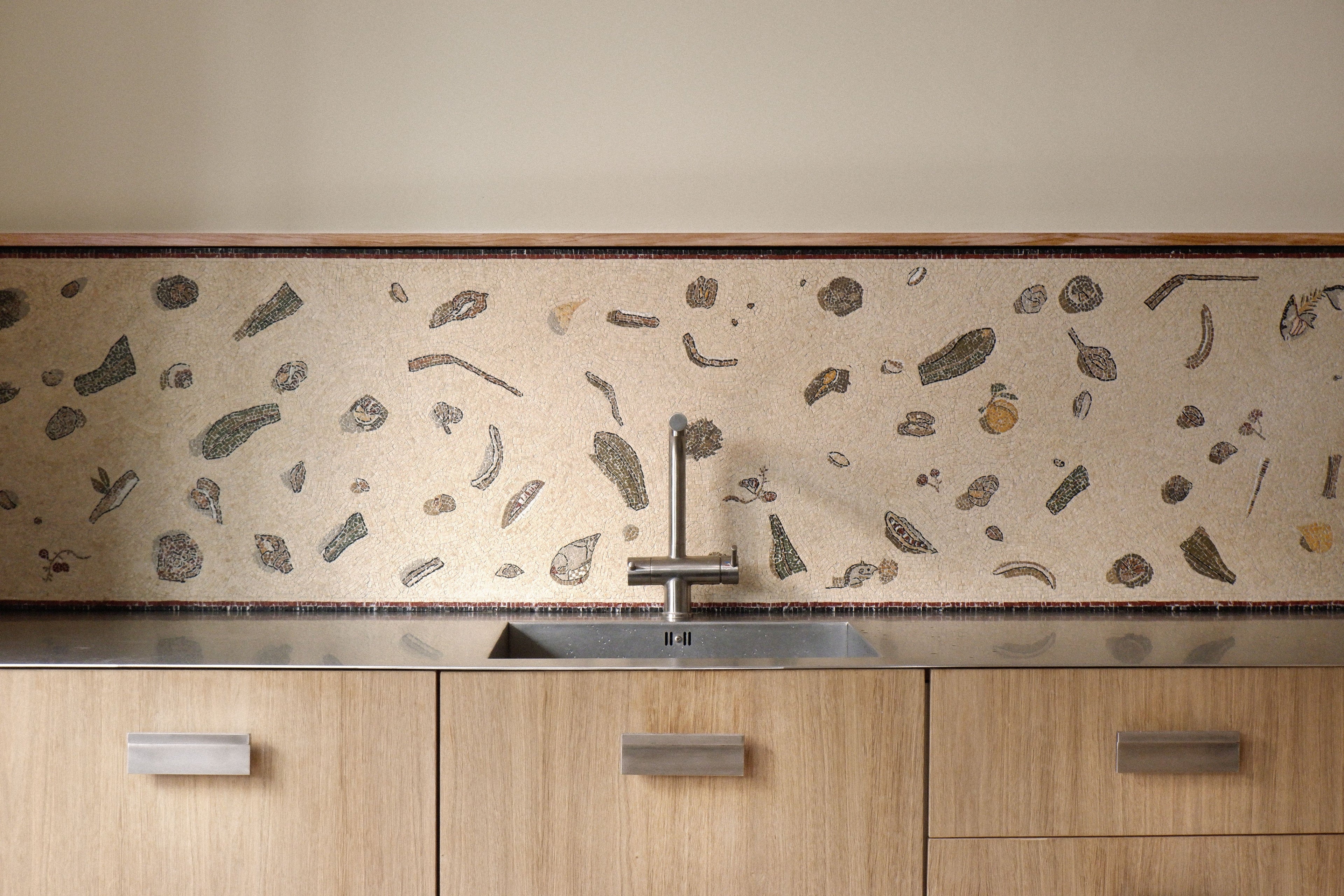 Modern kitchen with a speckled backsplash and wooden cabinets.